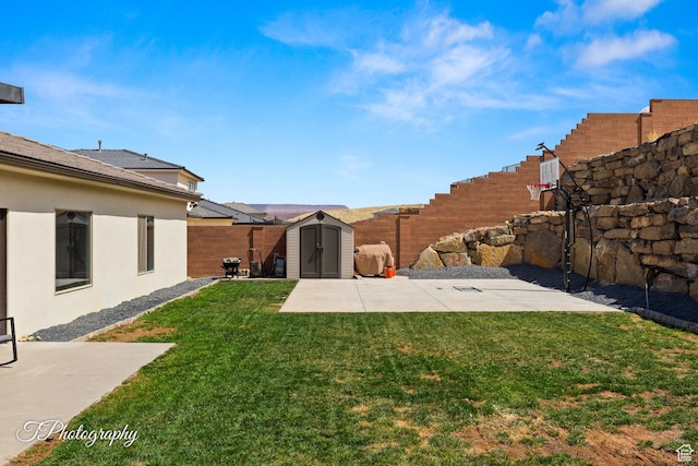 view of yard with an outdoor structure, a fenced backyard, a storage shed, and a patio area