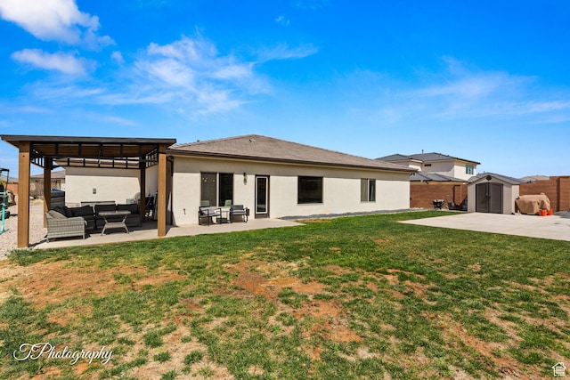 back of house featuring a storage shed, an outdoor living space, an outbuilding, a yard, and a patio area