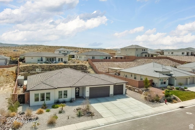 view of front of property with driveway, a garage, a tiled roof, and a residential view