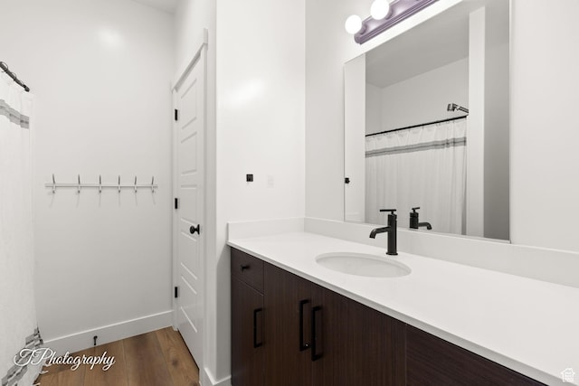 bathroom with vanity, baseboards, and wood finished floors