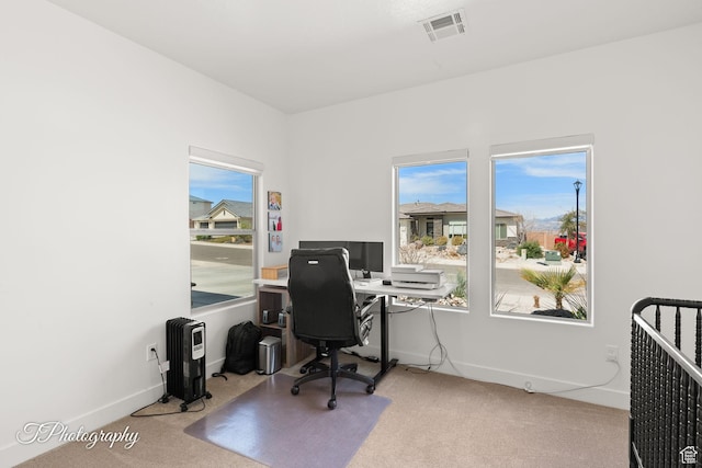 carpeted office featuring plenty of natural light, baseboards, and visible vents
