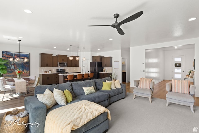 living area featuring recessed lighting, a ceiling fan, and light wood finished floors