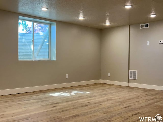 unfurnished room with wood finished floors, baseboards, recessed lighting, and a textured ceiling