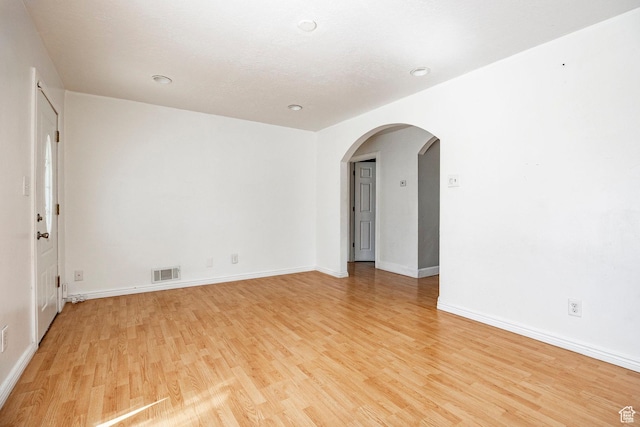 1150 W Girard Ave, Salt Lake City, UT 84116 - spare room featuring arched walkways, baseboards, light wood finished floors, and visible vents