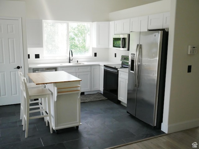6116 W Graceland Way, West Jordan, UT 84081 - kitchen with appliances with stainless steel finishes, a sink, a breakfast bar, light countertops, and white cabinets