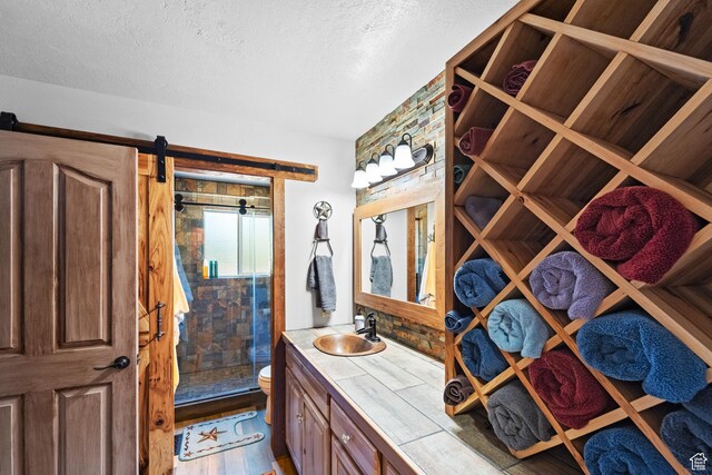 18509 Jefferson Ave, Eagle Mountain, UT 84013 - bathroom with a shower stall, a textured ceiling, vanity, toilet, and wood finished floors