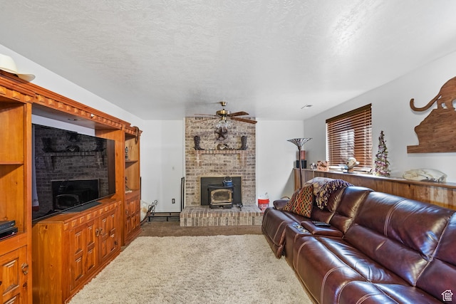carpeted living area featuring a ceiling fan, a wood stove, and a textured ceiling