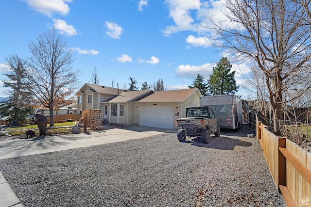 view of front of property featuring fence, a garage, and concrete driveway