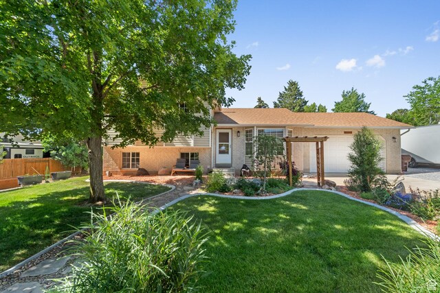18509 Jefferson Ave, Eagle Mountain, UT 84013 - tri-level home with a garage, brick siding, and concrete driveway