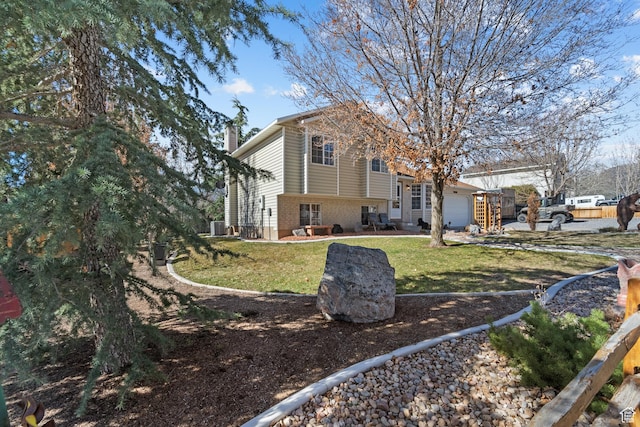view of side of home with a chimney, brick siding, a yard, and an attached garage