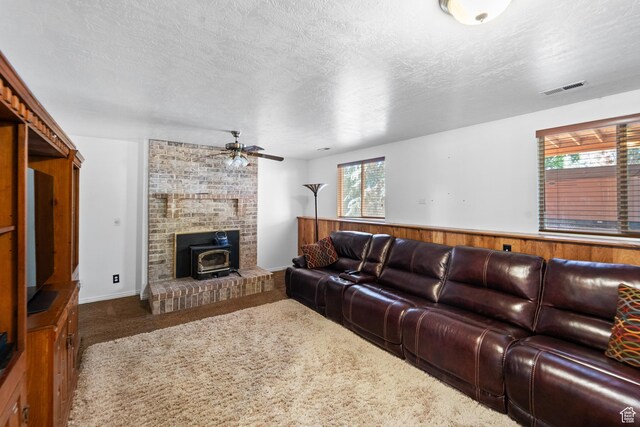 18509 Jefferson Ave, Eagle Mountain, UT 84013 - living area with a wood stove, healthy amount of natural light, ceiling fan, carpet floors, and a textured ceiling