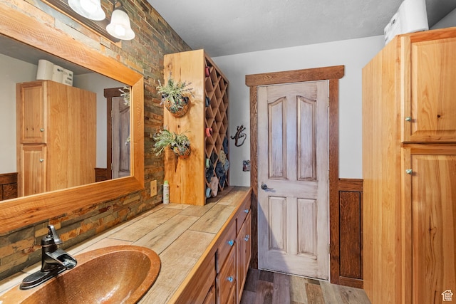 bathroom with wood finished floors and vanity