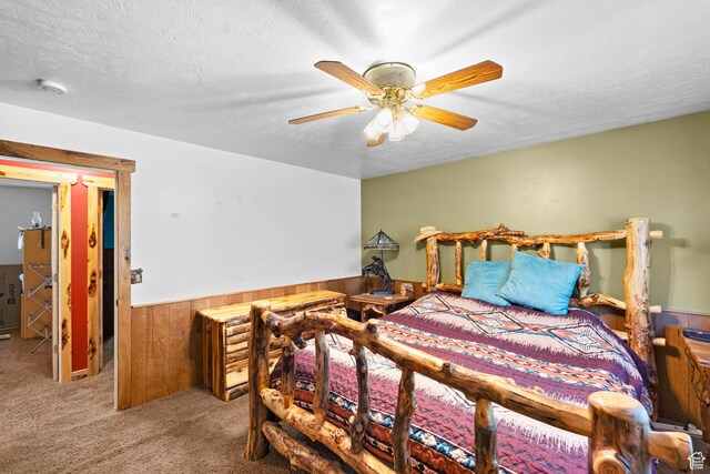 18509 Jefferson Ave, Eagle Mountain, UT 84013 - bedroom featuring wood walls, wainscoting, carpet floors, a textured ceiling, and ceiling fan