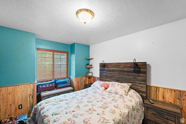 18509 Jefferson Ave, Eagle Mountain, UT 84013 - bedroom with wainscoting, wooden walls, and a textured ceiling