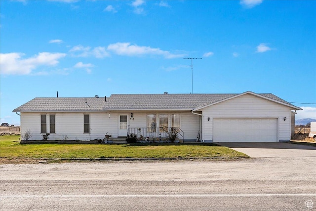 single story home with a front lawn, a porch, an attached garage, and concrete driveway