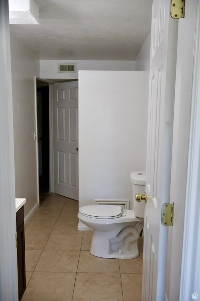 bathroom with toilet, tile patterned floors, and vanity