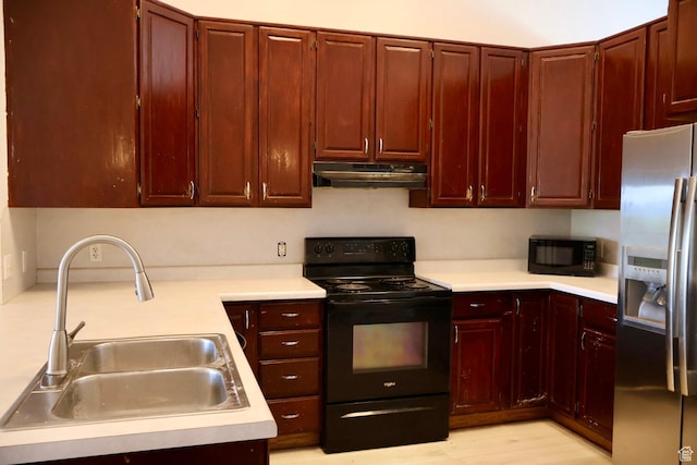 kitchen with black appliances, a sink, under cabinet range hood, reddish brown cabinets, and light countertops