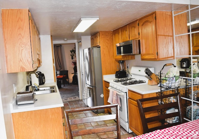 4759 S Pintail Ct, Salt Lake City, UT 84117 - kitchen with stainless steel appliances, a sink, light countertops, and brown cabinetry