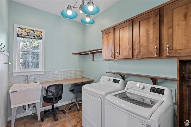 washroom with cabinet space, stone finish flooring, and washing machine and clothes dryer
