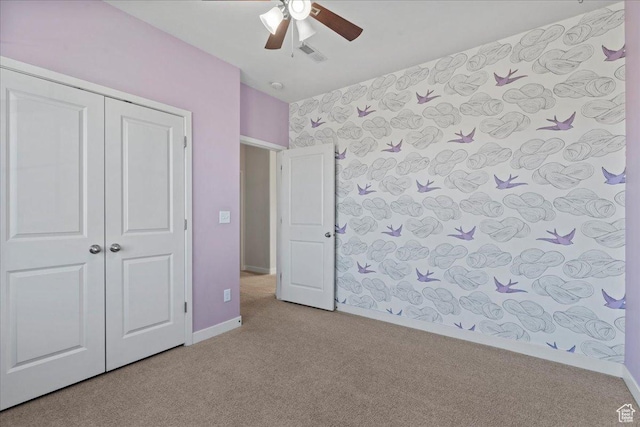 unfurnished bedroom with carpet flooring, visible vents, baseboards, a ceiling fan, and a closet