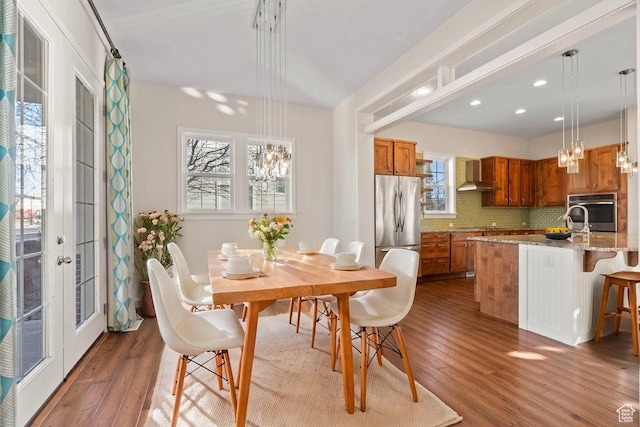 dining space featuring wood finished floors, recessed lighting, and a notable chandelier