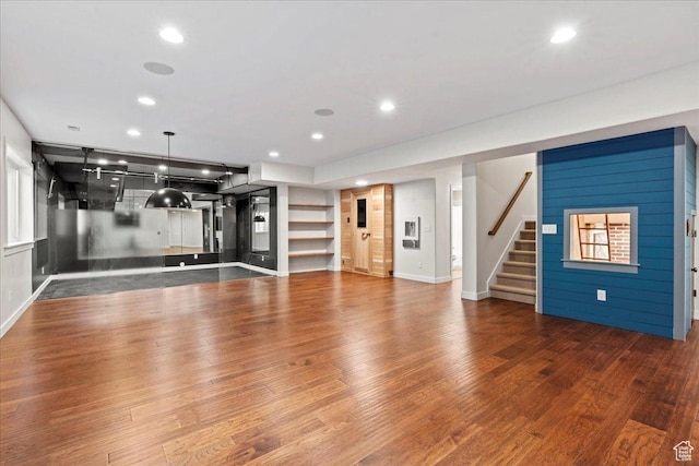 exercise room featuring baseboards, wood finished floors, and recessed lighting