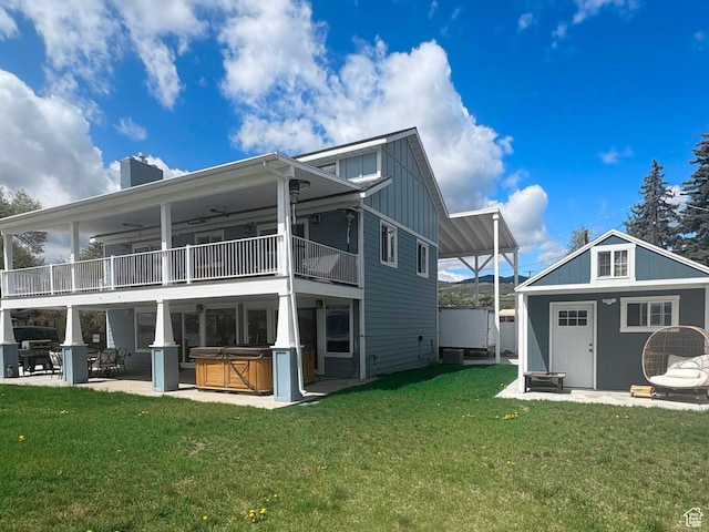 660 S Bear Lake Blvd, Garden City, UT 84028 - back of property featuring a hot tub, a balcony, board and batten siding, a chimney, and a patio area