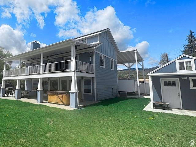 660 S Bear Lake Blvd, Garden City, UT 84028 - back of property with a hot tub, board and batten siding, a balcony, a lawn, and a patio