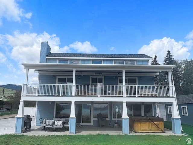 660 S Bear Lake Blvd, Garden City, UT 84028 - back of house featuring a hot tub, a balcony, a patio, and a chimney