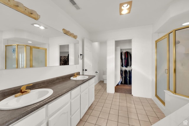 1867 E Indian Ln, Layton, UT 84040 - bathroom with a spacious closet, a shower stall, double vanity, and tile patterned flooring