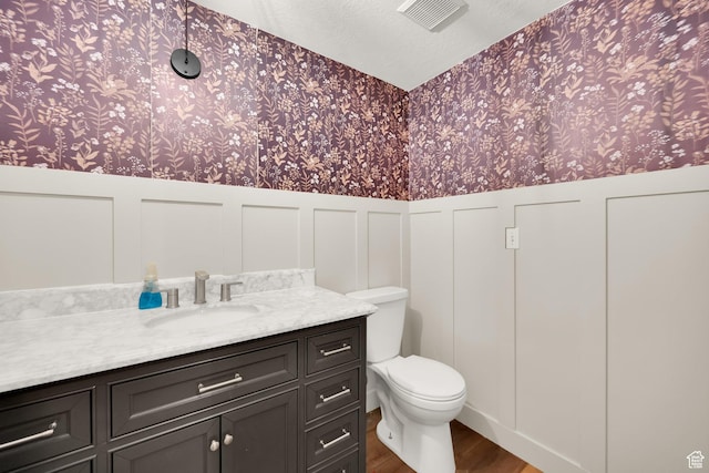 1867 E Indian Ln, Layton, UT 84040 - half bathroom featuring wallpapered walls, wainscoting, wood finished floors, and vanity