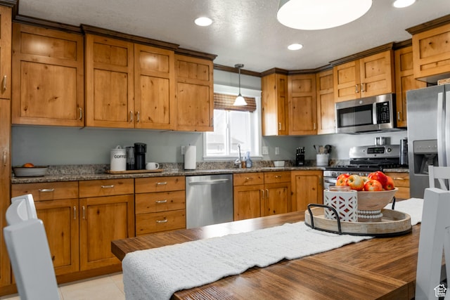 1348 W 200 S, Vernal, UT 84078 - kitchen with hanging light fixtures, brown cabinetry, and appliances with stainless steel finishes