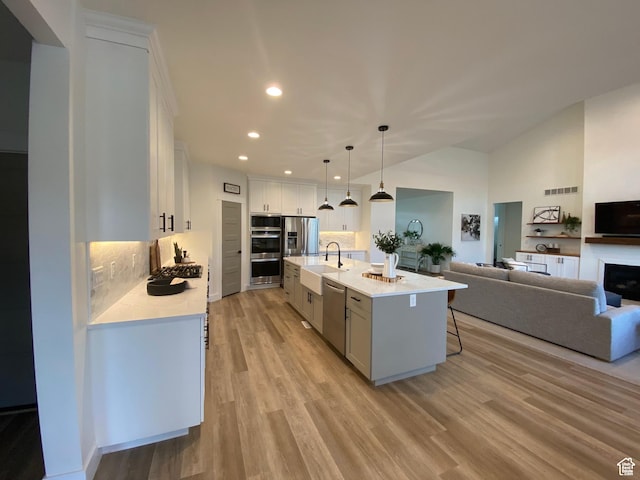 9940 N Vande Way, Eagle Mountain, UT 84005 - kitchen with open floor plan, light countertops, stainless steel appliances, a sink, and light wood-style flooring