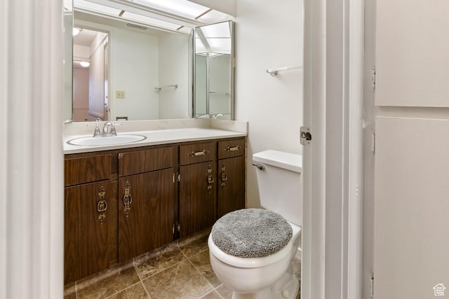 bathroom featuring toilet, vanity, and visible vents