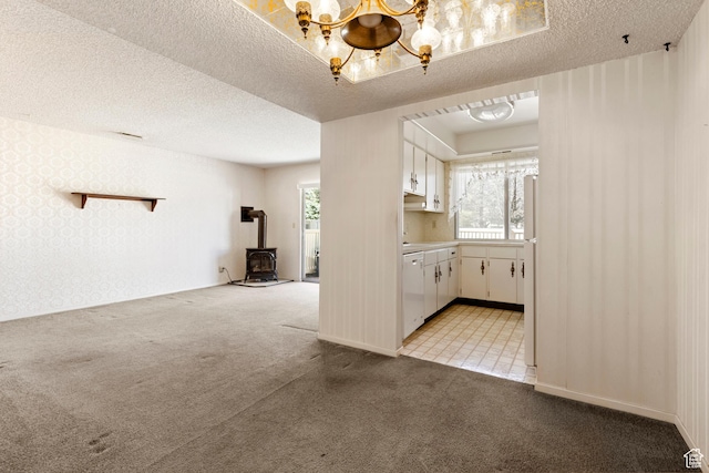 interior space with a textured ceiling, white cabinets, a chandelier, light carpet, and white dishwasher