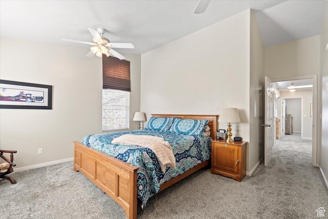 bedroom with vaulted ceiling, baseboards, light colored carpet, and ceiling fan