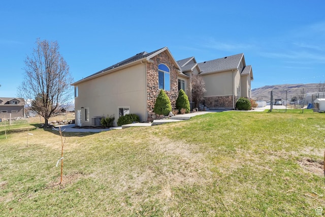 6092 W 13400 S, Herriman, UT 84096 - view of side of property featuring fence, stone siding, a lawn, and stucco siding