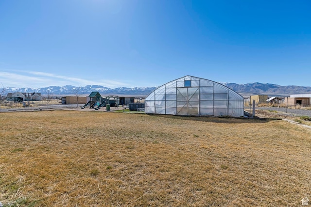 841 N Hale St Unit 1, Grantsville, UT 84029 - view of yard with an outdoor structure, a mountain view, a playground, and an exterior structure