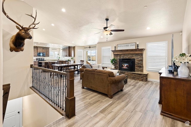 841 N Hale St Unit 1, Grantsville, UT 84029 - living room with ceiling fan, light wood-type flooring, vaulted ceiling, a stone fireplace, and recessed lighting