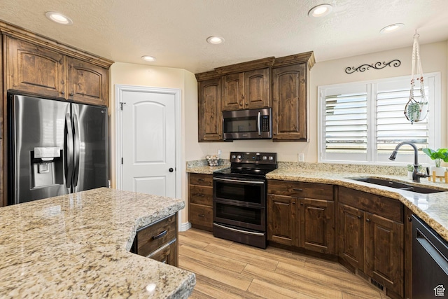 841 N Hale St Unit 1, Grantsville, UT 84029 - kitchen with a sink, appliances with stainless steel finishes, dark brown cabinets, wood finish floors, and light stone counters