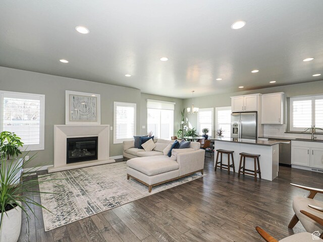 3631 W Cornstalk Way S, Riverton, UT 84065 - living area featuring a glass covered fireplace, a chandelier, recessed lighting, and dark wood finished floors