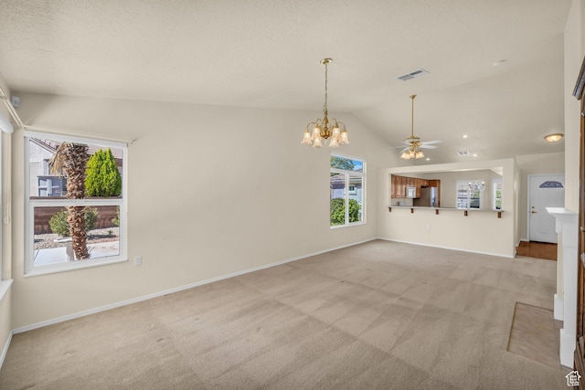 spare room with light carpet, lofted ceiling, a ceiling fan, baseboards, and a chandelier