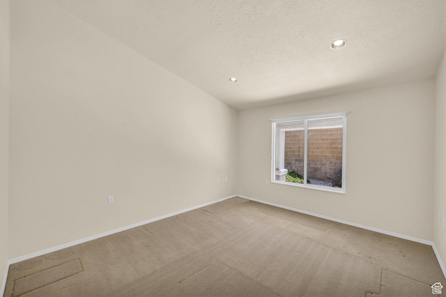 spare room featuring carpet flooring, baseboards, recessed lighting, and a textured ceiling