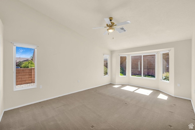 empty room featuring carpet, healthy amount of natural light, a ceiling fan, and baseboards