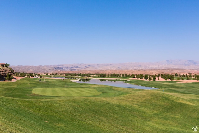 surrounding community featuring a water and mountain view, a yard, and view of golf course