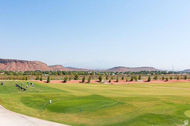 surrounding community with a mountain view, golf course view, and a lawn