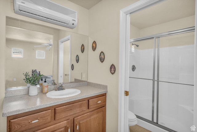 bathroom featuring an AC wall unit, a shower stall, ceiling fan, vanity, and toilet