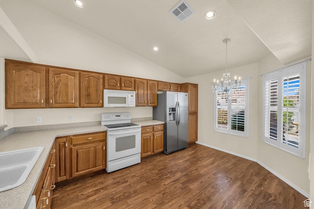 kitchen featuring white appliances, a chandelier, a sink, dark wood-style floors, and light countertops