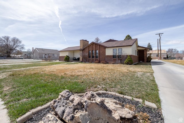 380 S 100 E, Vernal, UT 84078 - ranch-style home with brick siding, a front lawn, and a chimney