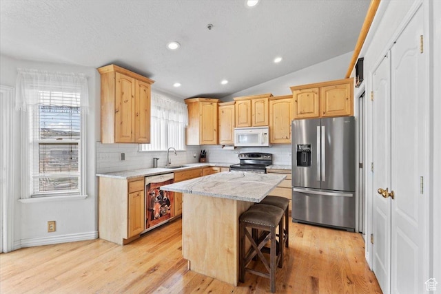 7217 W Mccuiston Ave S, Herriman, UT 84096 - kitchen with decorative backsplash, appliances with stainless steel finishes, a sink, vaulted ceiling, and light brown cabinetry